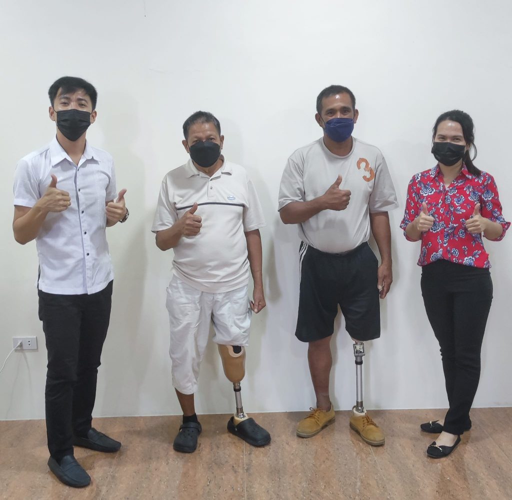 REU 12 Administrative Officer Exequiel Salcedo (left) and Information Officer Kaye Daga (right) pose with ECC beneficiaries of below and above-knee prostheses, Enrique Silva (second from left) and Jovy Aleta (third from left) on December 13, 2021.